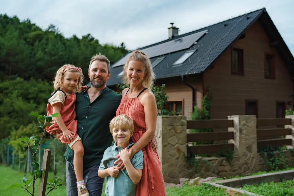 Gezin met twee kinderen staan voor hun landelijke huis.