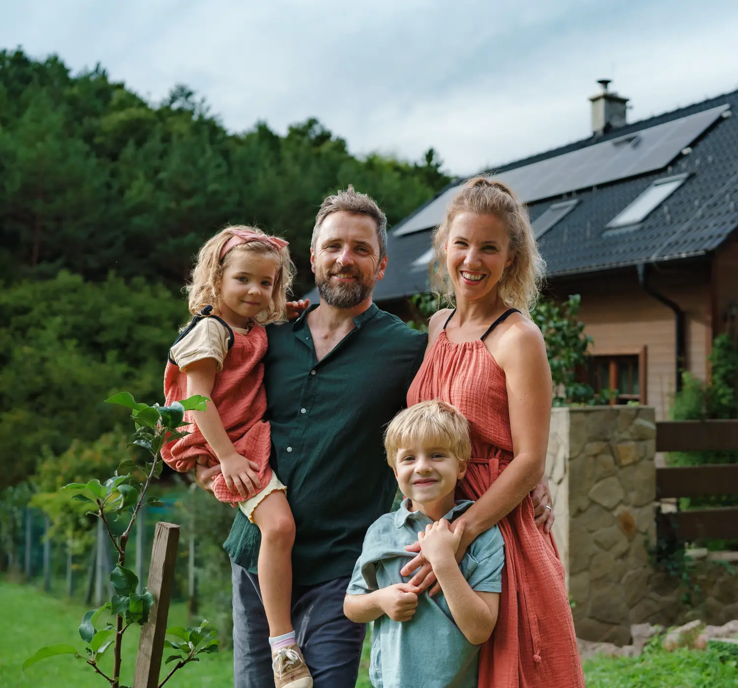 Gezin met twee kinderen staan voor hun landelijke huis.