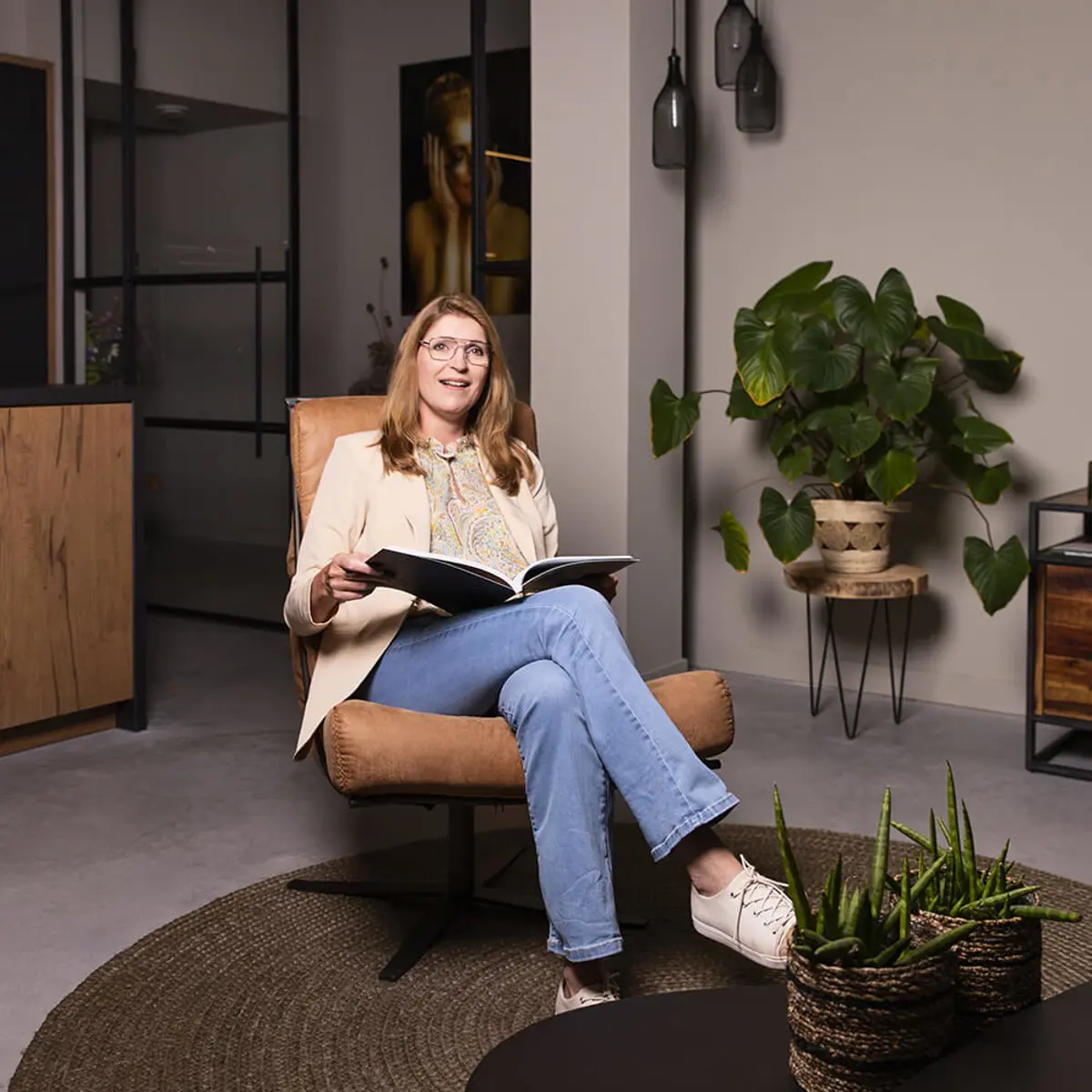 Vrouw leest boek in woonkamer